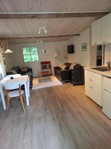 een woonkamer met een tafel en een keuken bij Hus in Orkelljunga +8 foto's