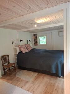 een slaapkamer met een zwart bed en een houten plafond bij Hus in Orkelljunga