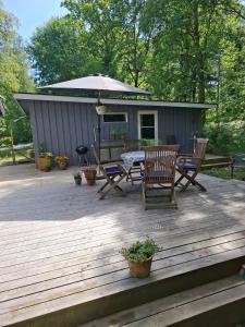 een picknicktafel en stoelen op een terras met een schuurtje bij Hus in Orkelljunga