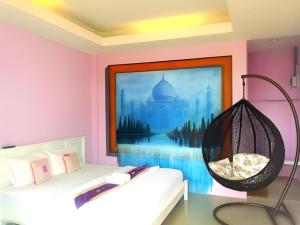 a room with a swinging chair and a picture of a mosque at Sixty-nine Resort in Ban Tha Khwai