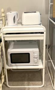 een magnetron op een plank met een broodrooster bij Costa del Pinner in Northwood