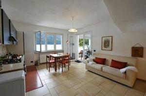 ein Wohnzimmer mit einem Sofa und einem Tisch in der Unterkunft Villa L'Approdo in Porlezza