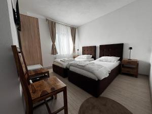 a hotel room with two beds and a table at Tudor's Rooms in Mediaş