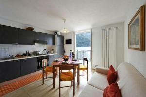 cocina y sala de estar con mesa y sofá en Villa L'Approdo, en Porlezza