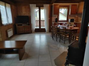 een eetkamer met een tafel, stoelen en ramen bij Location d'un chalet de vacances in Pont-de-Poitte +11 foto's