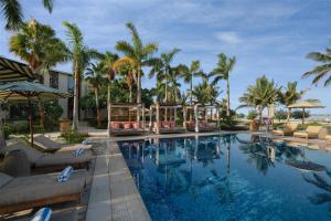 ein Pool in einem Resort mit Palmen in der Unterkunft Turtle Bay Resort - Red Sea in Ḩanak