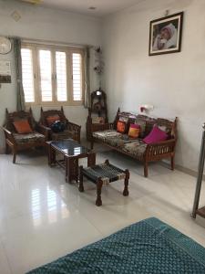 a living room with couches and tables in a room at Keshav in Bhuj