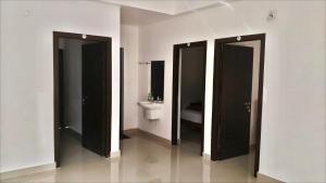 a bathroom with three stalls with a sink and a toilet at Smile Residency in Sultan Bathery