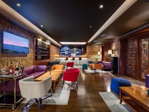 een restaurant met kleurrijke stoelen en tafels en een bar bij Mercure Tbilisi Old Town in Tbilisi City