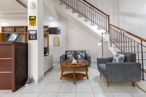 een woonkamer met twee stoelen en een tafel bij RedDoorz Plus near Universitas Maranatha Bandung 2 in Bandung