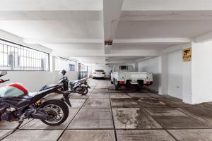 een garage met een motorfiets en een vrachtwagen erin bij RedDoorz Plus near Universitas Maranatha Bandung 2 in Bandung +16 foto's