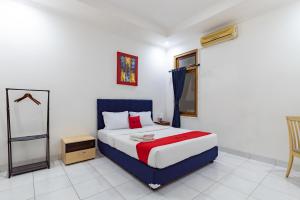 een slaapkamer met een kingsize bed en een spiegel bij RedDoorz Plus near Universitas Maranatha Bandung 2 in Bandung