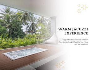 een badkamer met een badkuip en uitzicht op een bos bij Anumana De Suite in Ubud