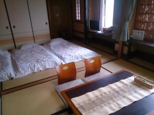 Ryokan Nakajimaya في كيوتو: غرفة بسريرين وطاولة وكراسي
