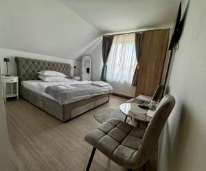 ein Schlafzimmer mit einem Bett, einem Tisch und einem Stuhl in der Unterkunft Tudors Rooms in Mediaş + 19 Fotos