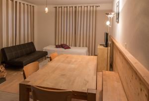 a living room with a table and a couch at Helvetia hotel in Morgins