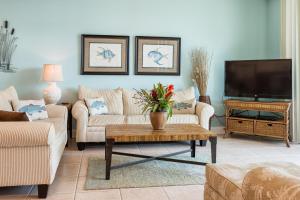 a living room with two couches and a tv at Phoenix on the Bay Unit 1110 in Orange Beach