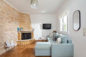 a living room with a blue couch and a fireplace at Villa Anastasis in Halikounas