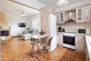 a kitchen and living room with a table and chairs at Villa Anastasis in Halikounas