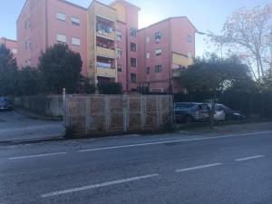 a fence on the side of a street with a building at Tree home in Salerno Airport - Aeroporto di Salerno