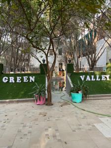 a tree in front of a green wall with plants at Green Valley Residency in Lucknow