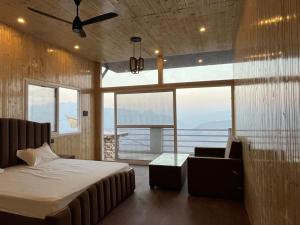 a bedroom with a bed and a couch and windows at Perry's Cottage in Faigul