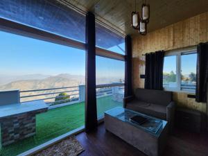 a living room with a couch and large windows at Perry's Cottage in Faigul