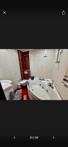 een badkamer met een bad en een toilet bij Вила Хоризонт-Албена in Balchik +7 foto's