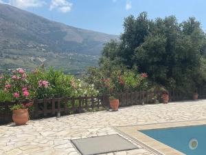 ein Garten mit Zaun, Blumen und einem Swimmingpool in der Unterkunft Villa Midas in Zóla
