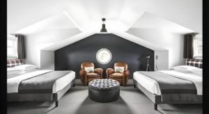 een slaapkamer met 2 bedden en 2 stoelen en een raam bij The George Montclair in Montclair