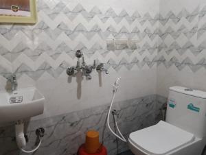 a bathroom with a toilet and a sink at Anurastays in Mudigere