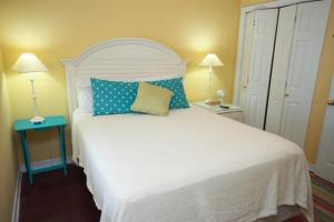 a bedroom with a large white bed with blue pillows at Grand Beach Resort Unit 106 in Gulf Shores