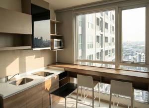 a kitchen with a counter with two chairs and a window at The Onnut Nest 1BR Sofa Bed Onnut BTS 50m in Bangkok