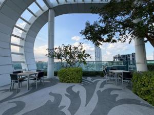 a patio with tables and chairs on a building at The Onnut Nest 1BR Sofa Bed Onnut BTS 50m in Bangkok