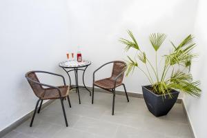 een patio met 2 stoelen en een tafel met een plant bij Habitación Fredolic in Castellví de la Marca