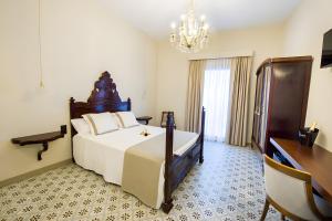 een slaapkamer met een groot bed en een kroonluchter bij Habitación Fredolic in Castellví de la Marca