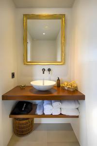 een badkamer met een wastafel, een spiegel en handdoeken bij Habitación Fredolic in Castellví de la Marca
