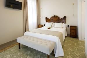 - une chambre avec un grand lit blanc et un banc dans l'établissement Habitación Rossinyol, à Castellví de la Marca