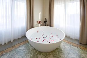 - une grande baignoire blanche dans une chambre avec fenêtres dans l'établissement Habitación Rossinyol, à Castellví de la Marca