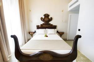 een slaapkamer met een houten bed met witte lakens bij Habitacion Cantarelus in Castellví de la Marca