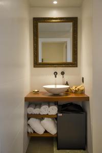 een badkamer met een wastafel, een spiegel en handdoeken bij Habitacion Cantarelus in Castellví de la Marca