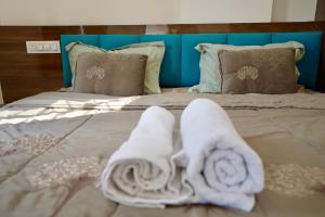 een bed met witte handdoeken en kussens erop bij One bedroom apartment in Indore