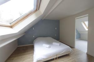 een slaapkamer met een bed met witte lakens en een raam bij Le clos des tirons in Chambon-sur-Cisse