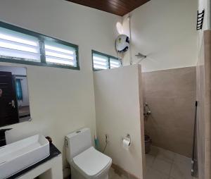 a bathroom with a toilet and a sink and a shower at Chara Farmhouse in Kohīma