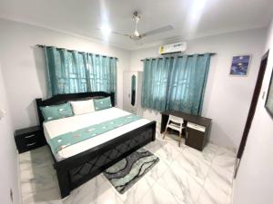 a bedroom with a bed and a desk in it at Happy Home in Weija