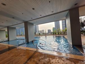 a large swimming pool in a building with a city skyline at 8 Adriatico Condominium 1BR in Sampong