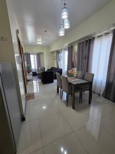 a dining room and living room with a table and chairs at 8 Adriatico Condominium 1BR in Sampong +7 photos