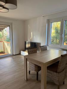 a dining room with a wooden table and chairs at Stadt Land Ferienhaus in Falkensee