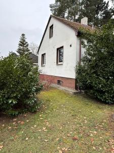 a white house with a window in a yard at Stadt Land Ferienhaus in Falkensee +6 photos