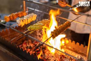 een hoop eten op een grill met vlammen bij StayVista at Jims Farmstay with Pool, Pet-friendly in Halgūr